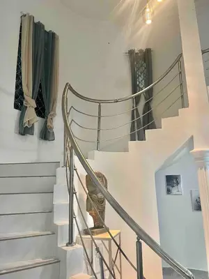 a spiral staircase in a home with green curtains at Villa Gordon in Santa Cruz de Barahona