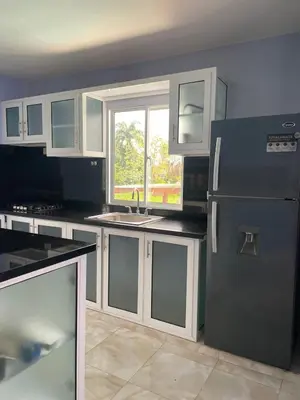 a kitchen with a black refrigerator and a window at Villa anastacia in Sabaneta de Yásica