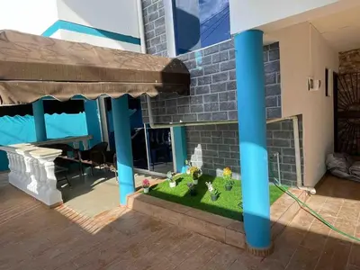a model of a house with blue columns and a yard at Acogedora Casa Vacacional in Colorado