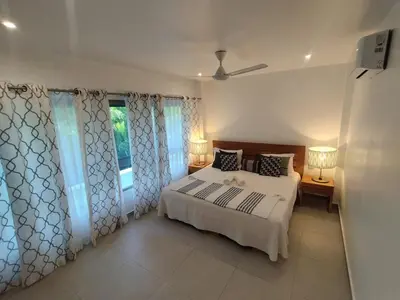 a bedroom with a white bed and a window at Comfort one step away from the beach in Las Terrenas