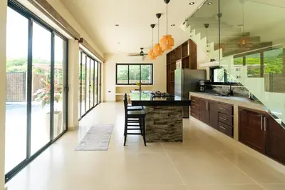 a kitchen with a table and chairs and windows at Casa Sharon in El Valle