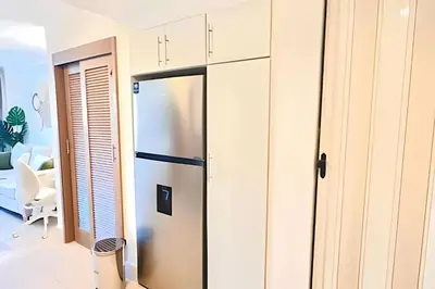 a kitchen with a stainless steel refrigerator in a room at Paraíso Soleado, apartamento en la playa in Sampiño