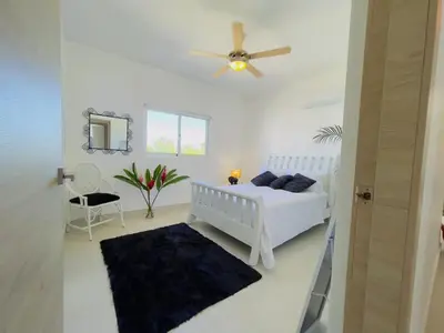 a white bedroom with a bed and a ceiling fan at 3BR & Rooftop Jacuzzi Near Beach in Las Terrenas