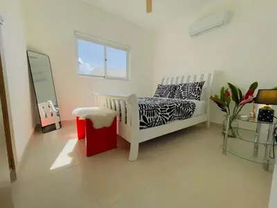 a room with a bed with a mirror and a window at 3BR & Rooftop Jacuzzi Near Beach in Las Terrenas