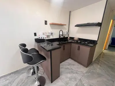 a kitchen with a sink and a counter and chairs at cerca de los mejores restaurantes I TV l Wifi in Constanza