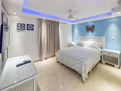 a bedroom with a bed and a blue wall at Garden Condo, Sosua in Sosúa