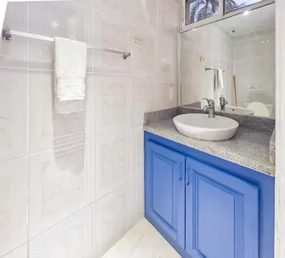 a white bathroom with a sink and a shower at Garden Condo, Sosua in Sosúa