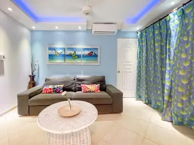 a living room with a couch and a table at Garden Condo, Sosua in Sosúa