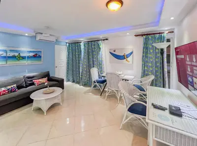 a living room with a couch and a table and chairs at Garden Condo, Sosua in Sosúa