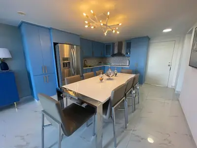a kitchen with blue cabinets and a table and chairs at Luxury apartment Playa Dorada in Puerto Plata