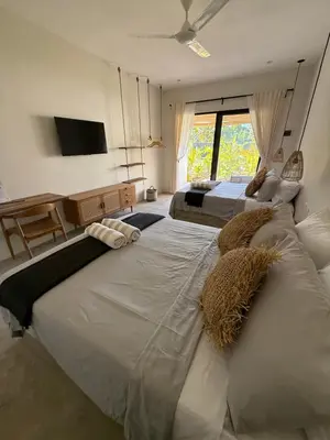 two large beds in a room with a window at Kaia Beach Lodge en Cosón in Las Terrenas