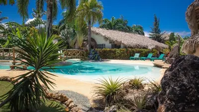a resort with a swimming pool and palm trees at Palmeras in Las Galeras