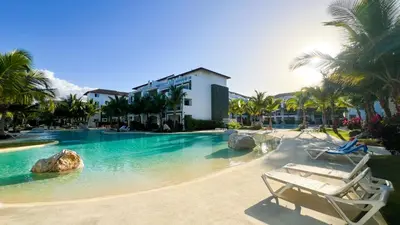a swimming pool in a resort with palm trees at Dimary Charming Apt, 5 Pools, Walk to the Beach Dominicus Bayahibe la Romana in La Laguna