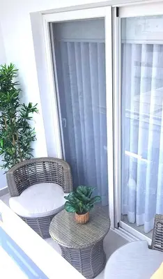 a balcony with two wicker chairs and a table at Dimary Charming Apt, 5 Pools, Walk to the Beach Dominicus Bayahibe la Romana in La Laguna