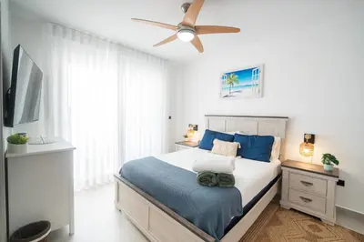 a bedroom with a bed and a ceiling fan at Dimary Charming Apt, 5 Pools, Walk to the Beach Dominicus Bayahibe la Romana in La Laguna