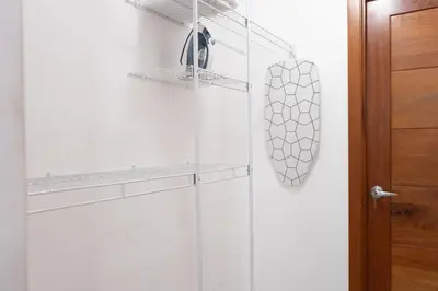 a shower with a glass door next to a wooden door at Apartment in Santo Domingo in Santo Domingo