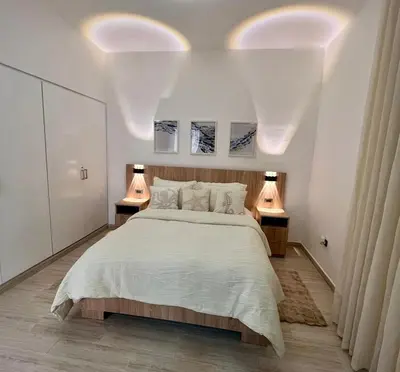 a bedroom with a bed with two lights on the ceiling at Maple Beach, apartamento en Punta Cana in Punta Cana