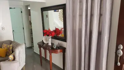 a living room with a table and a mirror at My hogar in Colorado