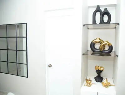 a room with a white door and a shelf with a mirror at Luxury Apartment in Santiago de los Caballeros