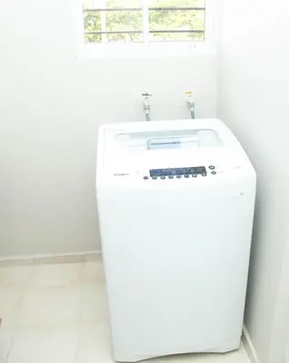a white washer and dryer in a white bathroom at Luxury Apartment in Santiago de los Caballeros