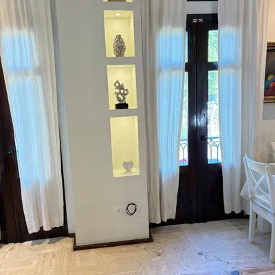 a room with white curtains and a door with a window at Casa De Mabel in Santo Domingo