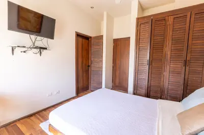 a bedroom with a bed and a tv on the wall at Casa De Mabel in Santo Domingo