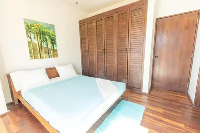 a bedroom with a bed and a wooden door at Casa De Mabel in Santo Domingo