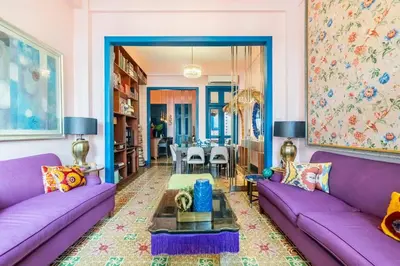 a living room with purple couches and a table at Stylish Colonial Townhouse in Santo Domingo's Historic Heart in Santo Domingo