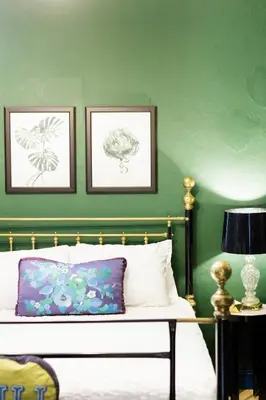 a bedroom with green walls and a bed with a pillow at Stylish Colonial Townhouse in Santo Domingo's Historic Heart in Santo Domingo