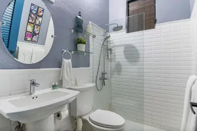 a bathroom with a sink and a toilet and a mirror at Stylish Colonial Townhouse in Santo Domingo's Historic Heart in Santo Domingo