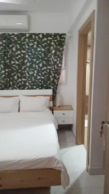 a bedroom with a white bed and a green wall at Cozy apartment in Boca Chica in Boca Chica