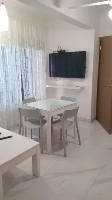 a dining room with a table and chairs and a television at Cozy apartment in Boca Chica in Boca Chica