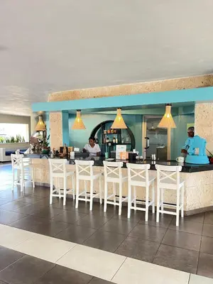a restaurant with white chairs and a bar at Juan Dolio paradise in Villas del Mar