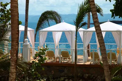 a deck with chairs and the ocean in the background at Bahia Principe Grand Samana - Adults Only in Santa Bárbara de Samaná