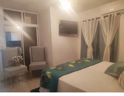 a bedroom with a bed and a tv and a chair at El Rincon de Sanchez