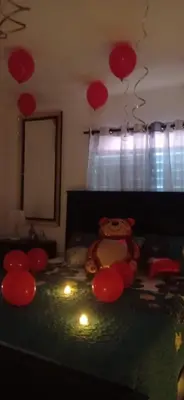 a teddy bear sitting on a bed with red lanterns at El Rincon de Sanchez