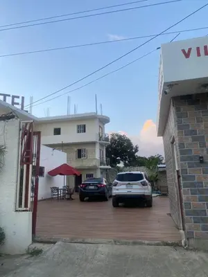 two cars parked in a parking lot in front of a building at Villa Hotel Saul & Lucas in Castillo