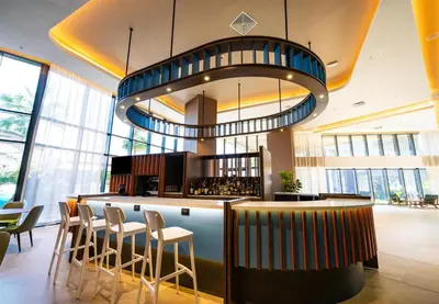a restaurant with a bar with chairs and a chandelier at Hotel Hampton By Hilton Santiago De Los Caballeros in Santiago de los Caballeros