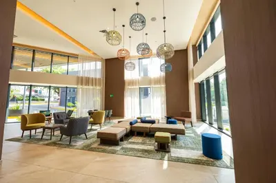 a living room with a couch and chairs and windows at Hotel Hampton By Hilton Santiago De Los Caballeros in Santiago de los Caballeros