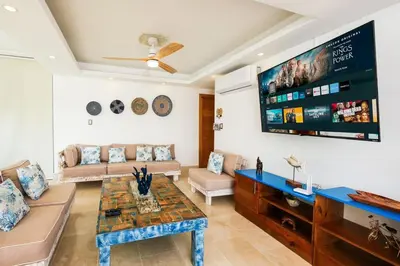a living room with a couch and a tv at Upper-Level Penthouse, Beachfront Residence in Las Terrenas