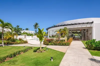 a building with a palm tree in a park at Upper-Level Penthouse, Beachfront Residence in Las Terrenas