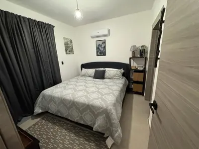 a bedroom with a bed with a gray comforter at Private Lux Oasis, Vista Cana, Punta Cana in Punta Cana