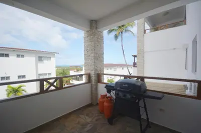 a balcony with a grill and a view of a building at Beautiful apartment with sea view in Las Terrenas