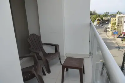a chair and a stool on a balcony at Relaxing Ocean View Getaway in Boca Chica501 in Boca Chica