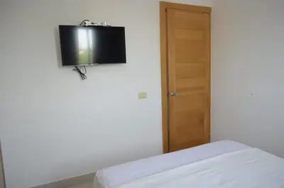 a room with a bed and a television on the wall at Relaxing Ocean View Getaway in Boca Chica501 in Boca Chica