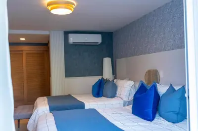 a bedroom with a bed with blue and white pillows at Xanadú in Sampiño