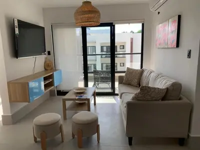 a living room with a couch and a tv at Prado Suites Luxurious Apartment for Long Term Stay in Las Terrenas