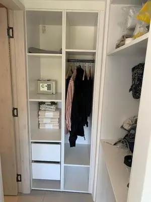 a walk in closet with white shelves and a door at Prado Suites Luxurious Apartment for Long Term Stay in Las Terrenas