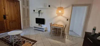 a living room with a small table and a television at Serenity Dominicus in La Laguna