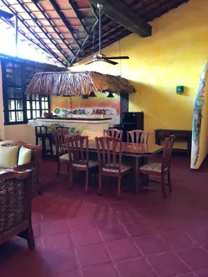 a dining room with a table and chairs and a surfboard at Hotel El Rancho Sosua in Sosúa